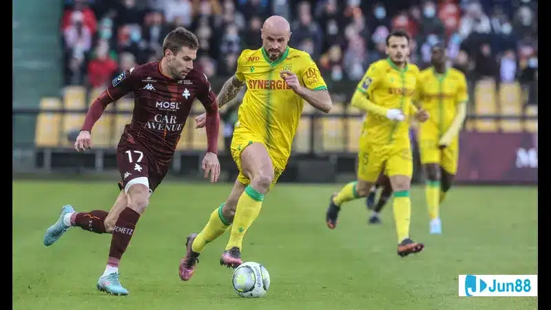 Cầu thủ của Nantes và Metz đua tốc độ để tranh bóng trước khán đài đầy khán giả